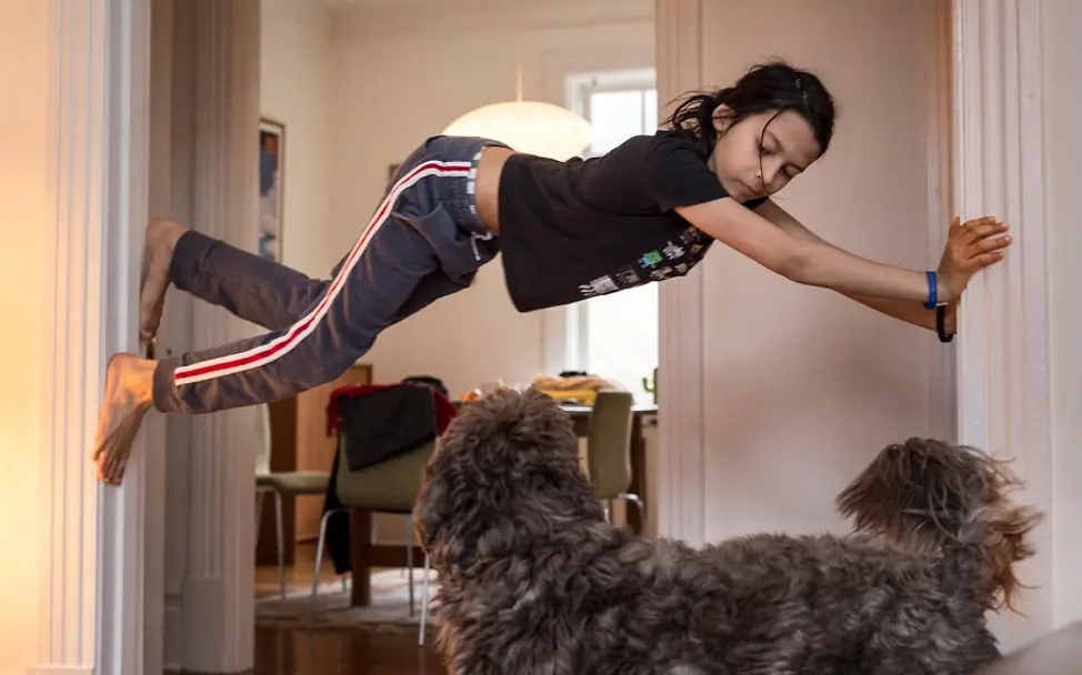 Ein Hund beobachtet Sascha gespannt beim Klettern. | © UNICEF/LeMoyne Kanada: Ein Junge kletter innerhalb eines Türrahmens.