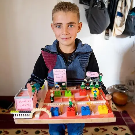 Ahmad präsentiert stolz seine Nachbildung der Wasseranlage. | © UNICEF/Herwig Jordanien: Ahmad mit seiner Nachbuldung aus Legosteinen.