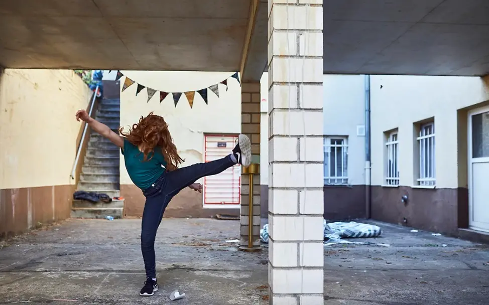 Der Spaß darf auch in Zeiten von Corona nicht fehlen. | © UNICEF/Bänsch Kindererziehung: Ein Mädchen tritt schwungvoll in die Luft.