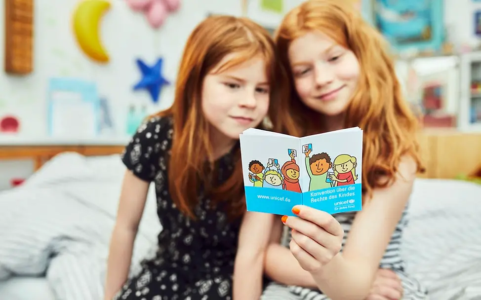 Hanna und Milena informieren sich über ihre Rechte. | © UNICEF/Bänsch Homeschooling: Zwei Mädchen lesen die UN-Kinderrechtskonvention.