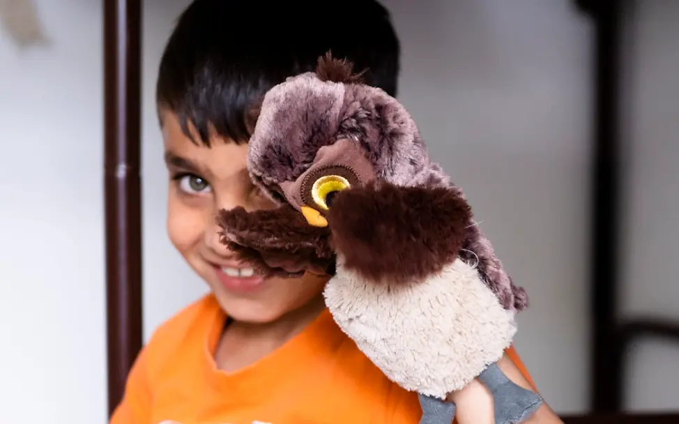 Ein Junge spielt in der Flüchtlingsunterkunft mit einer Handpuppe. | © UNICEF/Etges Flüchtlingsunterkunft Ellwangen: Junge mit Handpuppe.