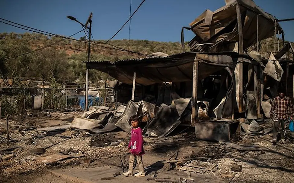 Kind vor niedergebrannter Unterkunft Kind vor niedergebrannter Unterkunft