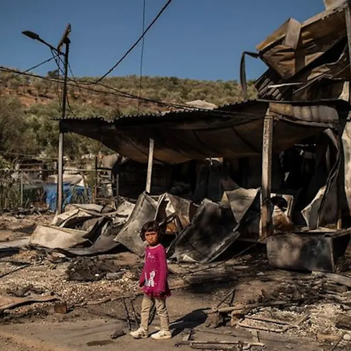 Kind vor niedergebrannter Unterkunft Kind vor niedergebrannter Unterkunft