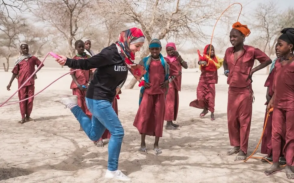 Muzoon versteht sich gut mit den einheimischen Kindern. | © UNICEF/Sokhin Tschad: Muzoon macht Seilspringen vor vielen Mädchen.