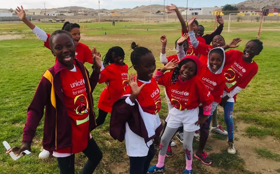 UNICEF hilft Mädchen in Namibia, sich gegen Aids zu schützen. | © UNICEF/NFA Eine Gruppe fußballspielender Mädchen in roten Trikots.