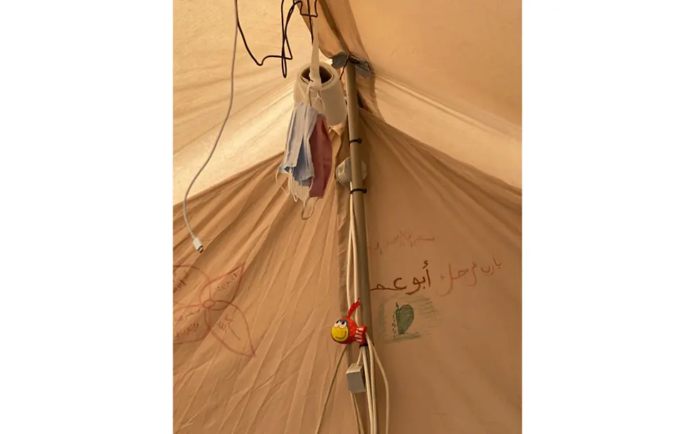 Ein neues provisorisches Zuhause in Kara Tepe. | © UNICEF/Berger Kara Tepe: Vom Zeltdach hängen Kabel und Masken herunter.