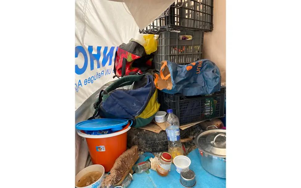 Die Familie verstaut ihre Lebensmittel am Zelteingang. | © UNICEF/Berger Kara Tepe: An einem Zelteingang liegen Lebensmittel.