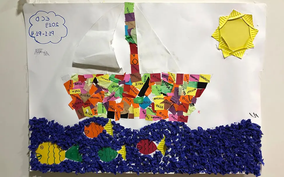 Kinder haben im Elix Learning Center Zeit zum Basteln. | © UNICEF/Berger Athen: Ein gebasteltes Bild von einem Segelboot im Elix Learning Center.