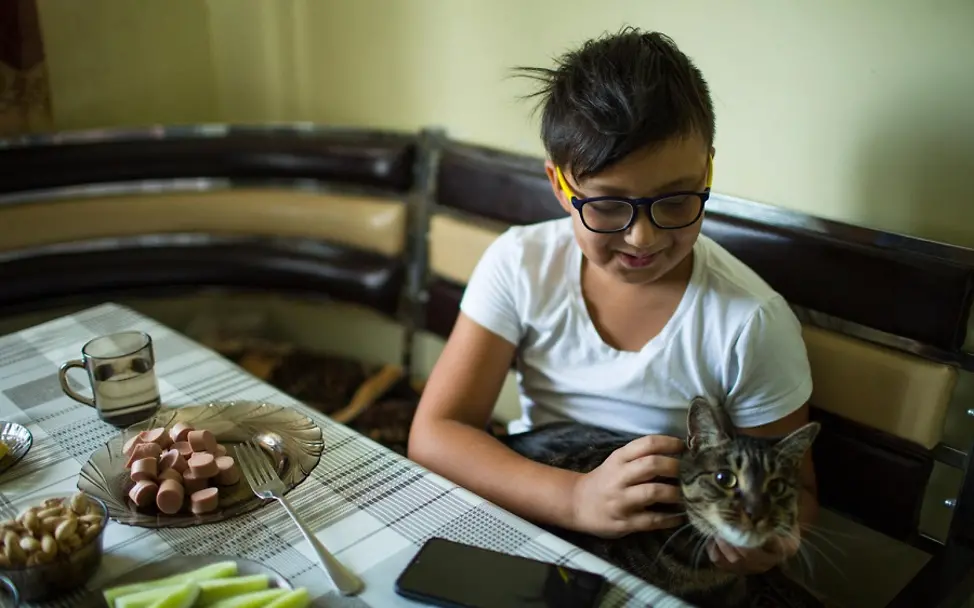 Yerzhan isst Würstchen zum Frühstück. | © UNICEF/Karimova Kasachstan: Yerzhan isst Würstchen zum Frühstück.