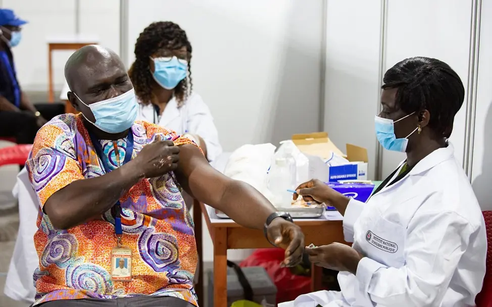 Impfen hilft Ländern mit schwachen Gesundheitssystemen: Ein Gesundheitshelfer erhält eine Impfung gegen Covid-19. 