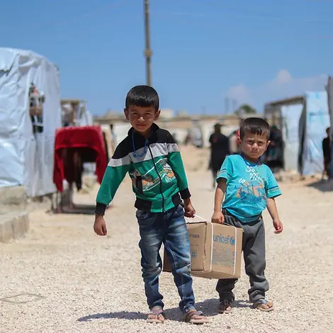 Ahmad und Saad tragen ein Hygiene-Kit. | © UNICEF/Almatar Ahmad und Saad tragen ein Hygiene-Kit.