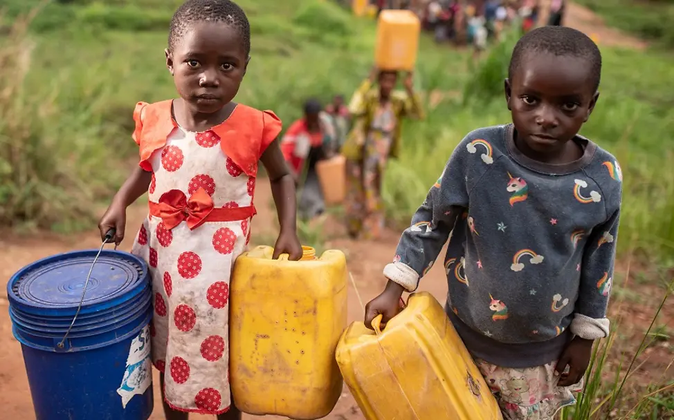 Weltwassertag 2021: Zwei Kinder in der Demokratischen Republik Kongo tragen Behälter zum Wasserholen.