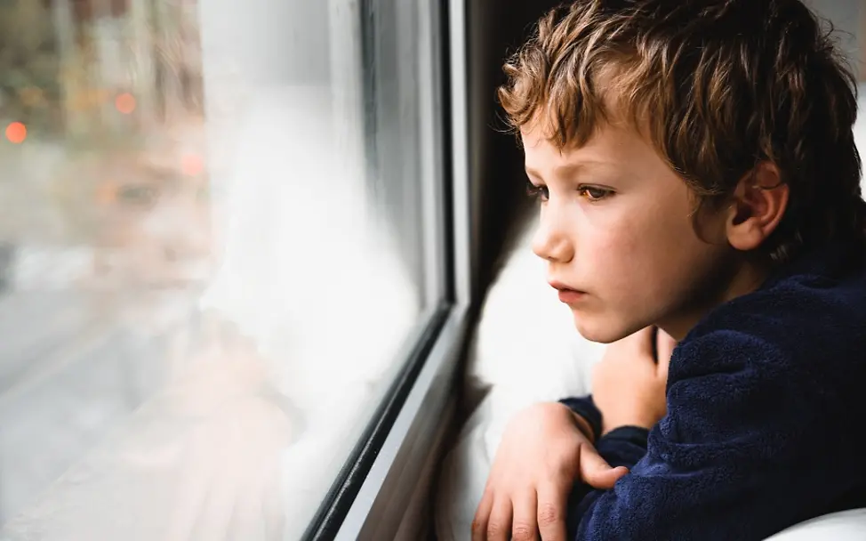 Kinder in Deutschland | © Joaquin Corbalan P/shutterstock.com Kinder in Deutschland: Junge schaut aus dem Fenster