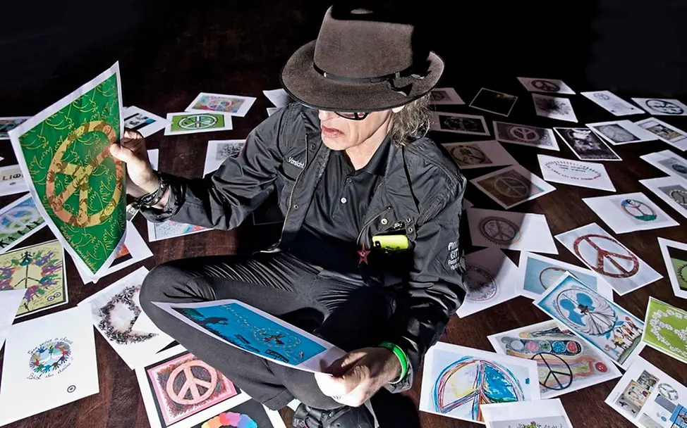 Udo Lindenberg bestaunt die Ergebnisse der Peace-Zeichen-Aktion.