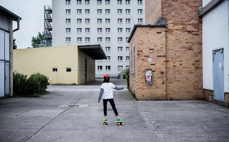 Joudi fährt vor der Flüchtlingsnotunterkunft in Karlshorst Rollschuh. | © UNICEF/Gilbertson VII Photo Deutschland: Die elfjährige Joudi fährt vor der Flüchtlingsnotunterkunft Rollschuh.