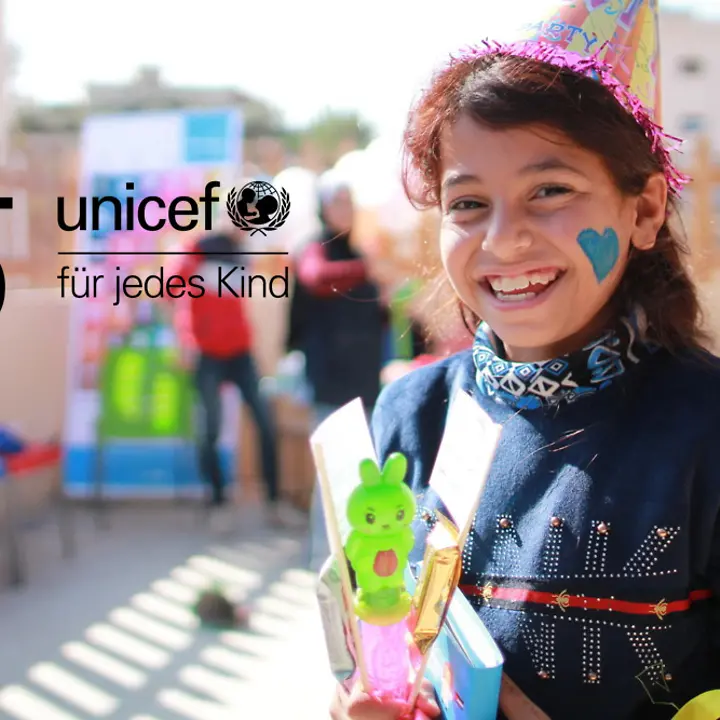 75 Jahre UNICEF - lächelndes Mädchen mit blauem Herz auf der Wange 75 Jahre UNICEF - lächelndes Mädchen mit blauem Herz auf der Wange