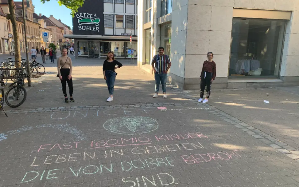 mit Straßenmalkreide hat das UNICEF Juniorteam Erlangen Auswirkungen des Klimawandels auf die Kinderrechte aufgemalt Juniorteam Erlangen engangiert sich zur Aktion actonclimate