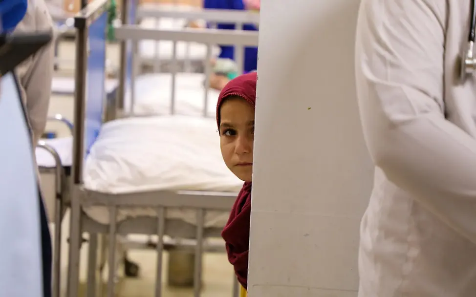 Afghanistan: Wir dürfen die Kinder nicht im Stich lassen | © UNICEF/Fazel Ein Kind schaut im Indira Gandhi Kinderkrankenhaus hinter einer Wand hervor.