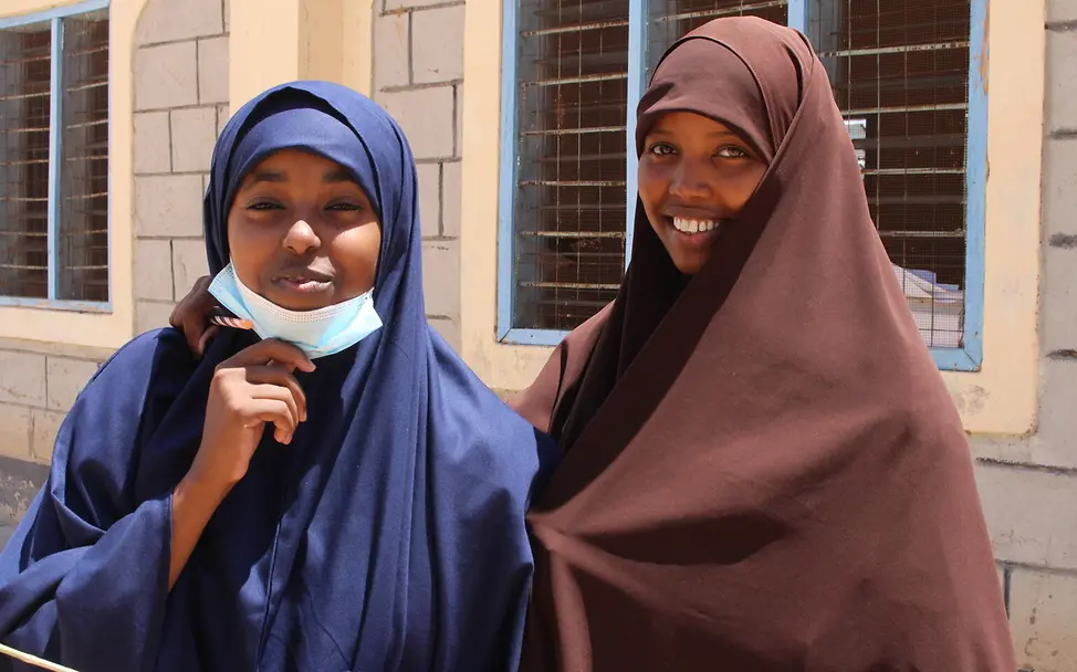 Anzal und eine ihrer Freundinnen in der Saka Mädchenschule. | © UNICEF/Kesper Anzal und eine ihrer Freundinnen lächeln für die Kamera in der Saka Mädchenschule.