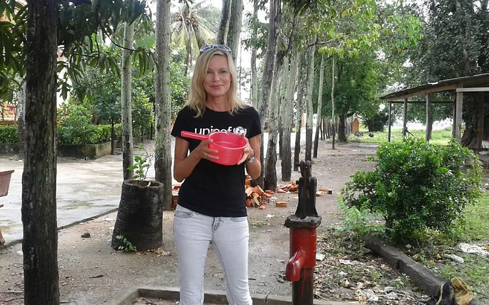 Nina Ruge neben einer rotgefärbten Wasserpumpe © UNICEF DT/2013/Berger Nina Ruge neben einer rotgefärbten Wasserpumpe © UNICEF DT/2013/Berger