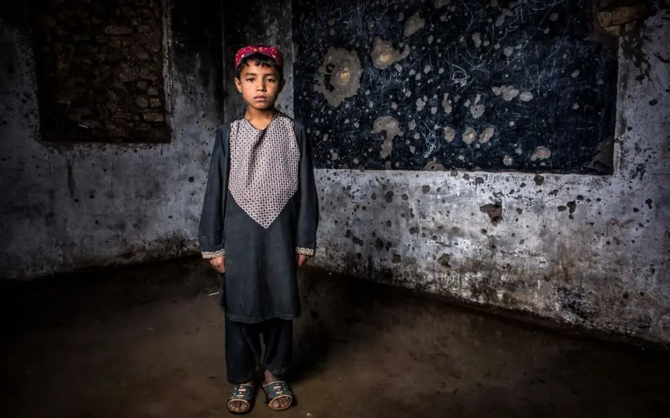Afghanistan: Abdul Hamid (9) in seinem mit Einschüssen übersäten Klassenzimmer | © UNICEF/UN0309065/Kokic UN0309065_online