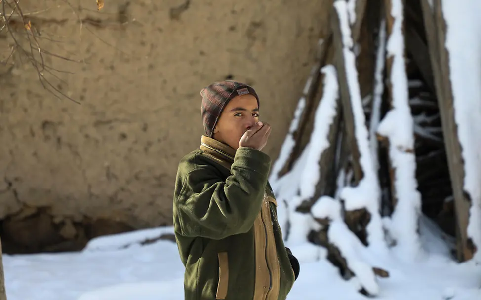 Winter in Afghanistan: Ein Junge steht im Schnee und wärmt seine Hände | © UNICEF/Fazel Winter in Afghanistan: Ein Junge steht im Schnee und wärmt seine Hände