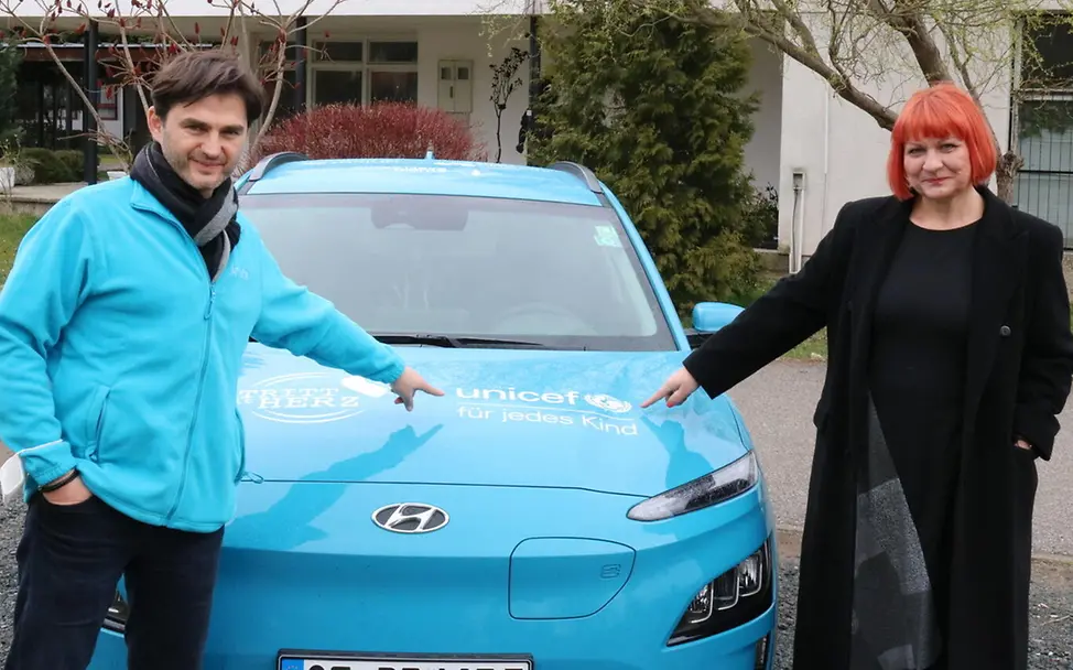 Aleksandra Milković und Lenn am Auto | © UNICEF/Ilej Aleksandra Milković und Lenn am Auto