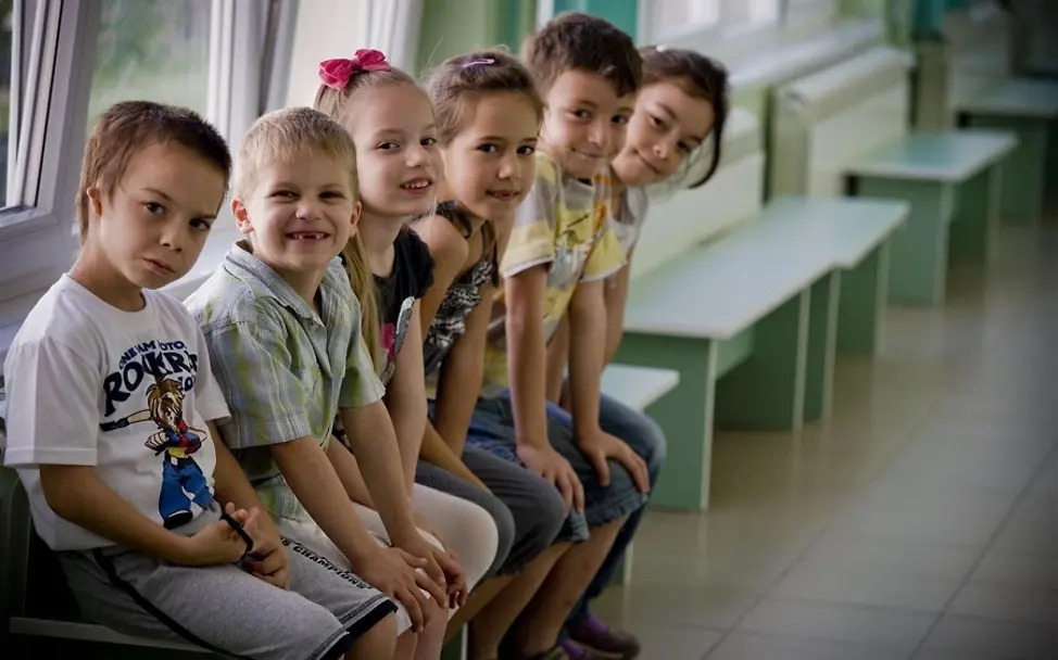 Eckpunktepapier zur EU-Kindergarantie | © UNICEF/Holt Kinder sitzen auf einer Bank