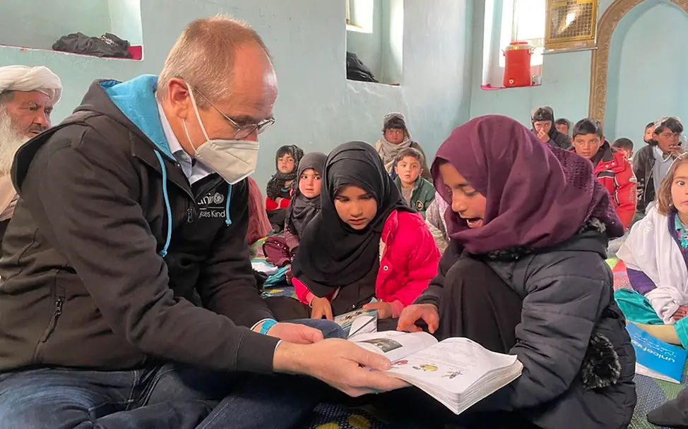 Afghanistan: Herr Schneider von UNICEF Deutschland liest mit Schülerinnen | © UNICEF/Kahmann Afghanistan: Herr Schneider von UNICEF Deutschland liest mit Schülerinnen