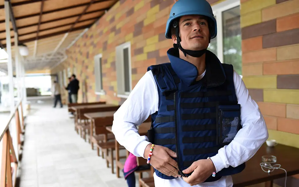 Am 28. April 2016 bereitet sich UNICEF-Botschafter Orlando Bloom auf den Besuch in der Ostukraine vor. | © UNICEF/Georgiev Orlando Bloom trägt Schutzhelm und Weste.