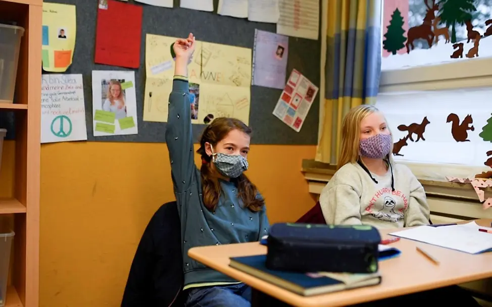 Zwei Jahre Corona-Pandemie | © UNICEF/Unruh Corona: Schülerinnen sitzen mit Maske in der Schule und beteiligen sich am Unterricht.