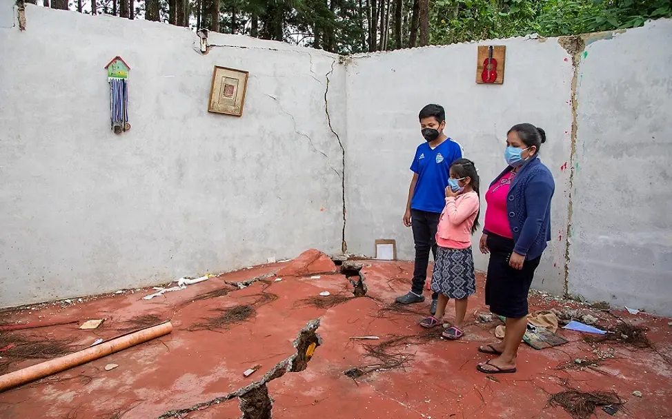 Eine Familie steht in ihrem zerstörten Zuhause.