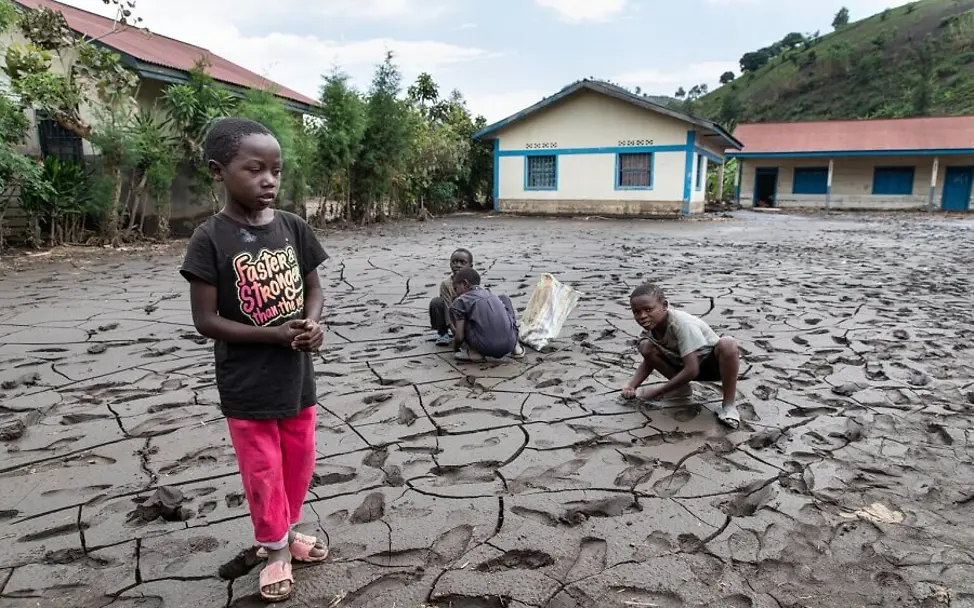 Kinder stehen auf einem zerstörten Feld.