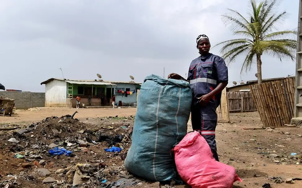 Ki Mariam zeigt einen großen Müllsack.