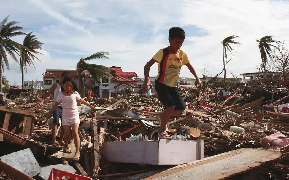 Kinder klettern durch Trümmer in Tacloban. © UNICEF/Maitem Kinder klettern durch Trümmer in Tacloban. © UNICEF/Maitem