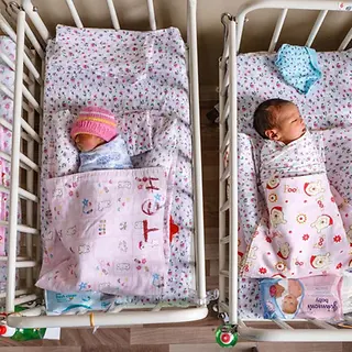 Sterblichkeit unter Säuglingen senken: Vier Babys liegen in ihren Betten auf einer Neugeborenen-Station.