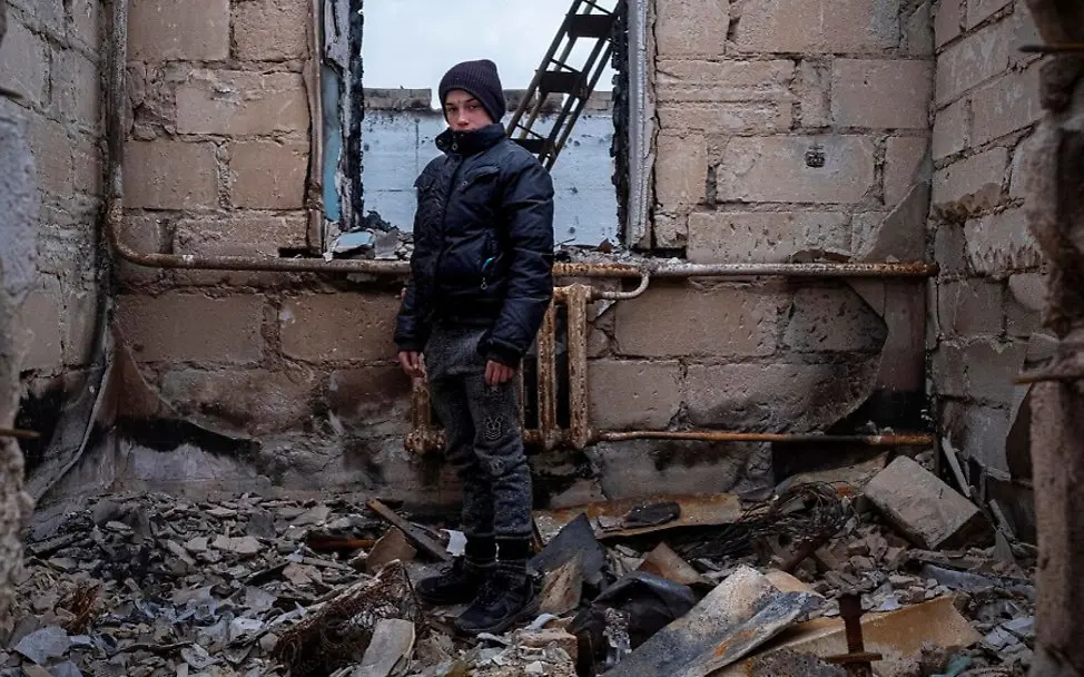 Der zwölfjährige Danylo aus der Ukraine steht in den Ruinen eines Hauses. | © UNICEF/Gilbertson Ein Junge steht in den Ruinen eines Hauses.