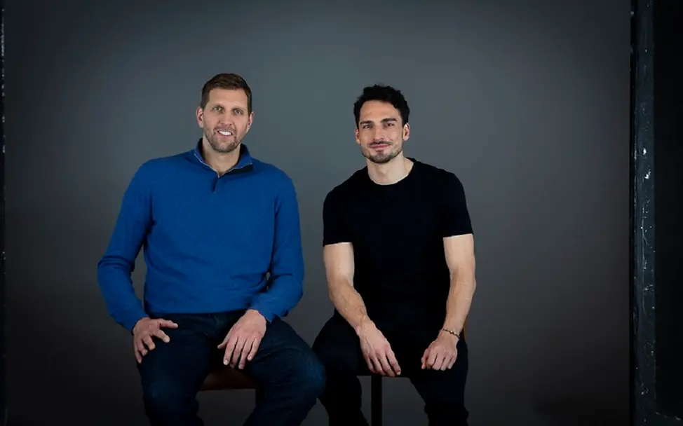 Schule für jedes Kind – Nowitzki und Hummels für UNICEF | © UNICEF/Stefan Freund Dirk Nowitzki und Mats Hummels sitzen auf zwei Stühlen und schauen in die Kamera.