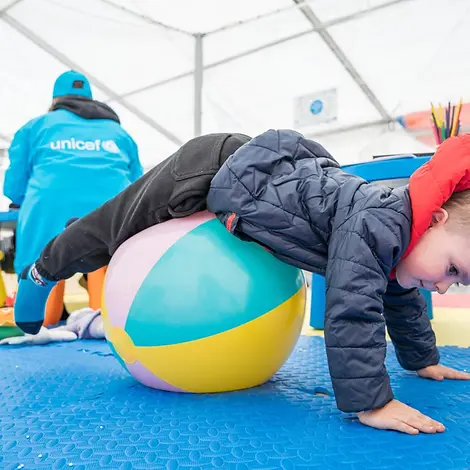 UNICEF | Hilfe für Kinder in der Ukraine: Ein kleiner Junge rollt über einen Ball in einer "Blue Dot"-Anlaufstelle in Rumänien.