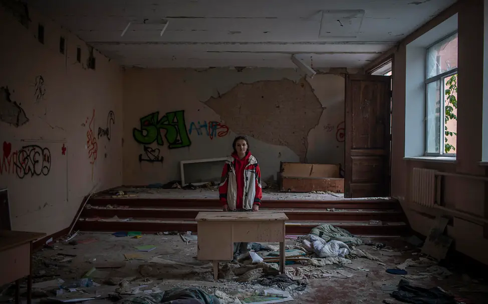 Darya steht in ihrem zerstörten Klassenzimmer in Tschernihiw in der Ukraine. © UNICEF/Ibarra Sánchez Darya steht in ihrem zerstörten Klassenzimmer in der Ukraine.