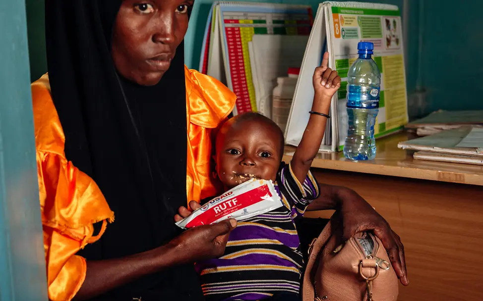 Kind erhält Erdnusspaste. Kind erhält Erdnusspaste.