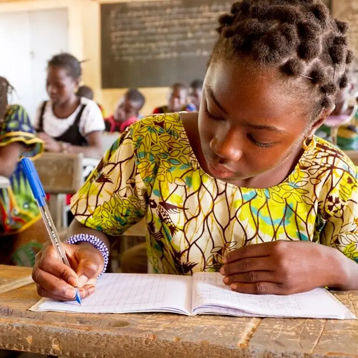 Schulhefte Ein Mädchen schreibt in der Schule in das Heft