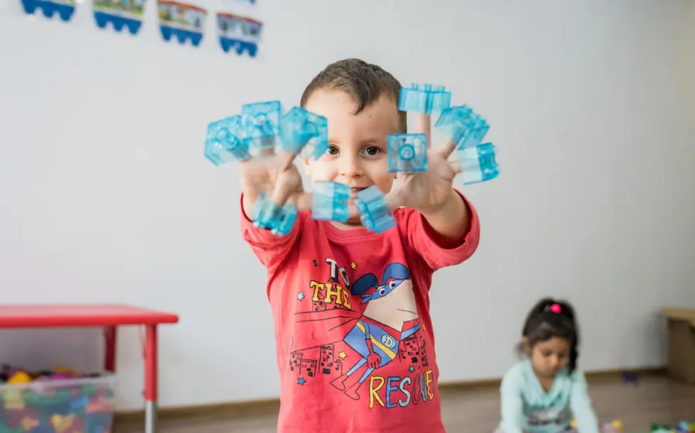 Rumänien: Ein Junge spielt mit LEGO Steinen 