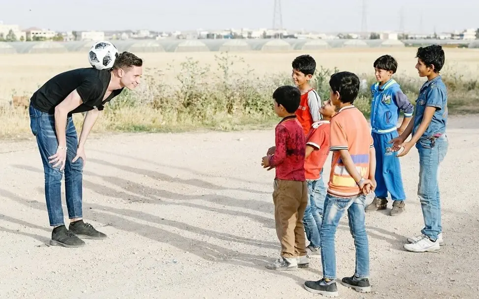 Julian Drexler im Camp Zaatari. | © UNICEF/Hertrich Jordanien: Julian Draxler zeigt den Kindern einen Fußballtrick