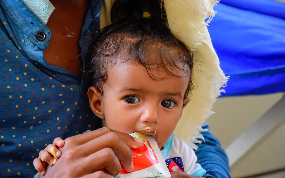 Elf Millionen Kinder im Jemen benötigen humanitäre Hilfe I UNICEF/UN0806465/ Ein kleiner Junge wird mit Erdnusspaste gefüttert.