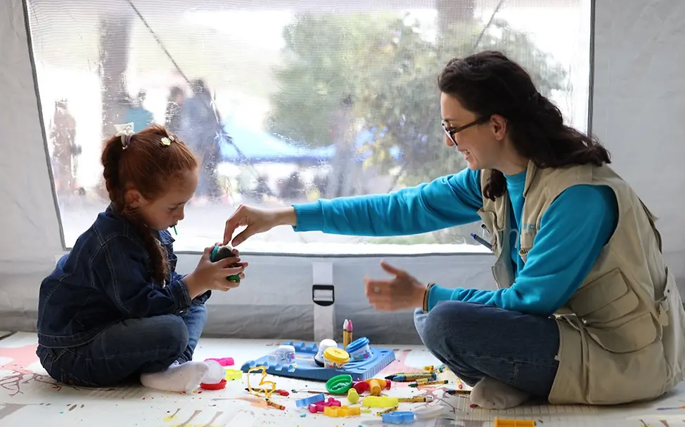 Geflüchtete Kinder in Armenien sind psychisch schwer belastet | UNICEF/Martirosyan Armenien: Eine Frau und ein Mädchen sitzen auf dem Boden und spielen mit einem Kuscheltier