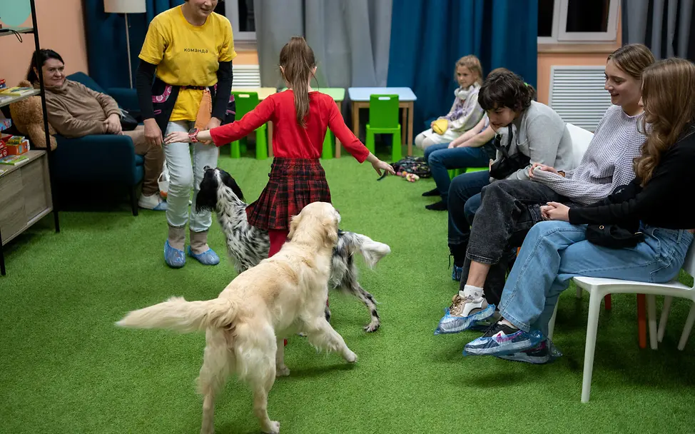 Kuschliges Fell und ein guter Freund an seiner Seite: Hundetherapie in der Ukraine. | © UNICEF/Filippov Kinder spielen mit Hunden in einem Kinderschutzzentrum in Charkiw.