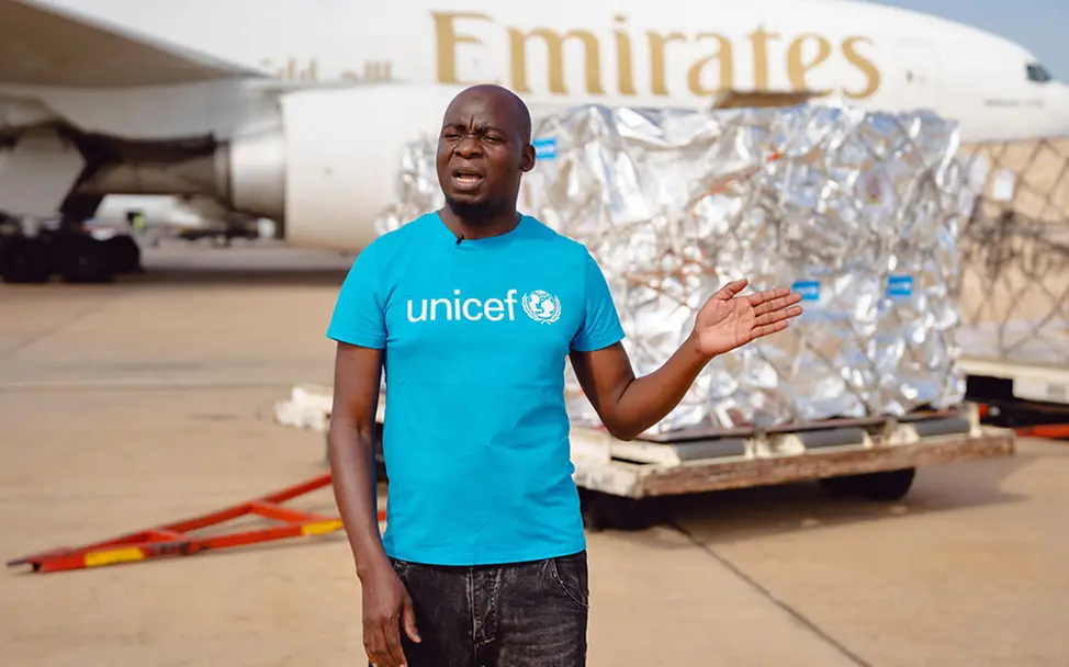 Ein UNICEF-Helfer zeigt die entladenen Malaria-Impfstoffe. | © UNICEF/Bakali Malaria Impfung: Ein UNICEF-Gesundheitsspezialist in Malawi zeigt die eben entladenen Malaria-Impfstoffe.