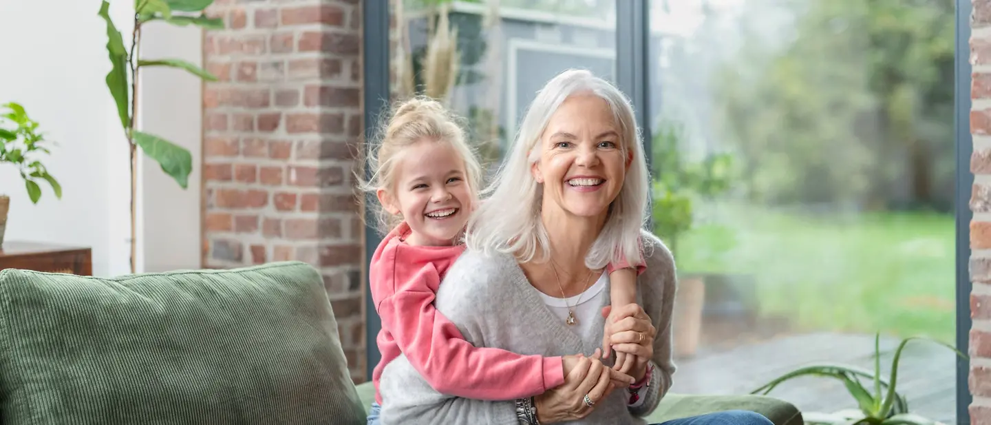 Testamentsgestaltung mit UNICEF | © UNICEF/Lindenthal-Lazhar Eine Oma und ihre Enkelin sitzen gemeinsam auf dem Sofa
