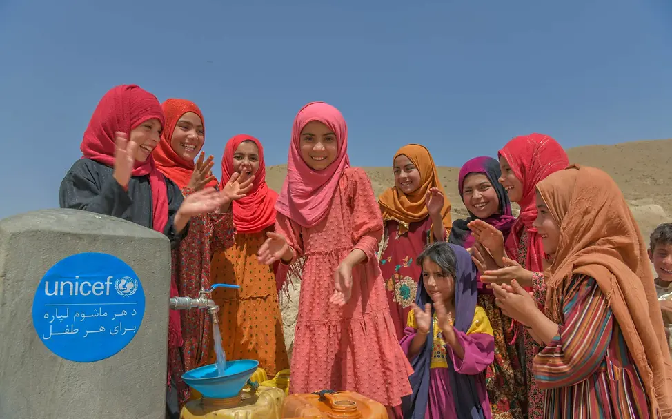 Afghanistan: Mädchen holen an einem Brunnen Wasser | © UNICEF/Karimi Mädchen in Afghanistan füllen an einem Brunnen Wasser in Kanister.